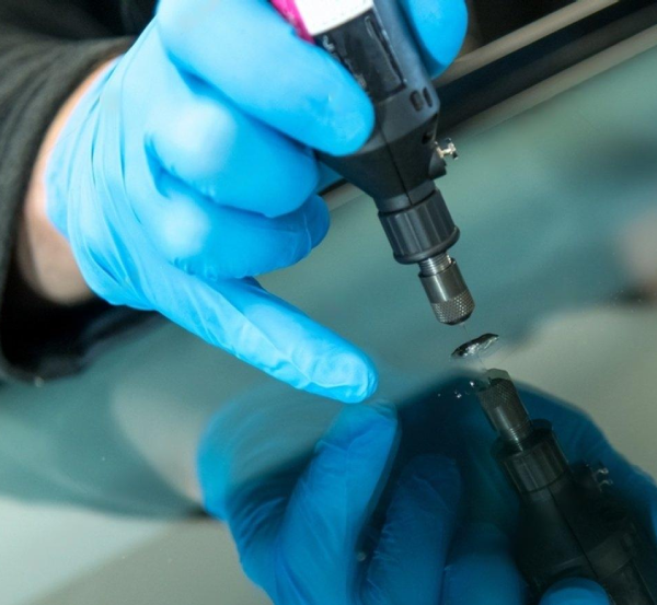 Technician performing rock chip repair on a windshield at Glassco Richmond