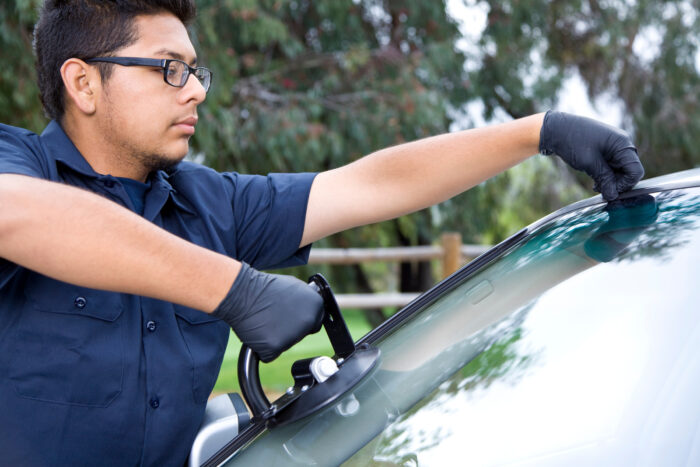 man repairing auto glass repair in Surrey